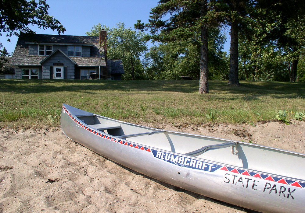 A canoe on the sandy shore of Annie Battle Lake in Glendalough State Park